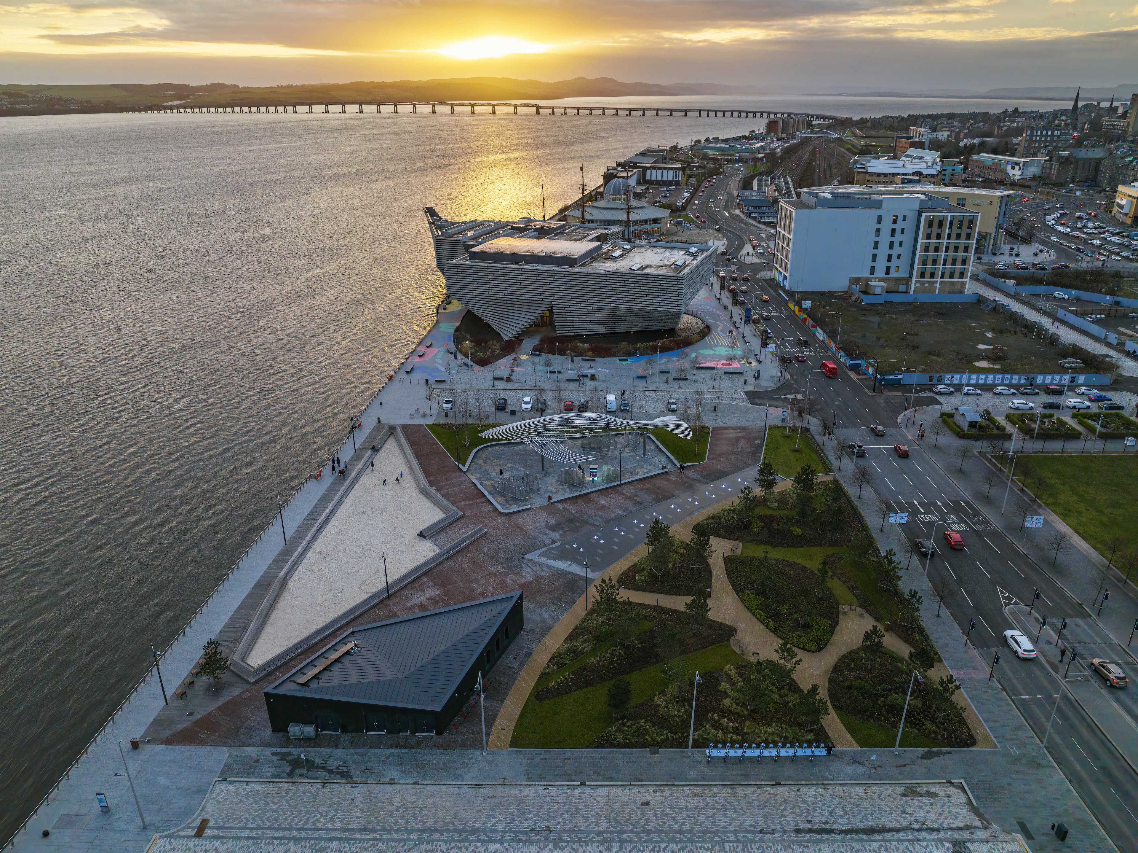 A drone shot of Dundee waterfront, including the urban beach, V&A Dundee and the RRS Discovery.